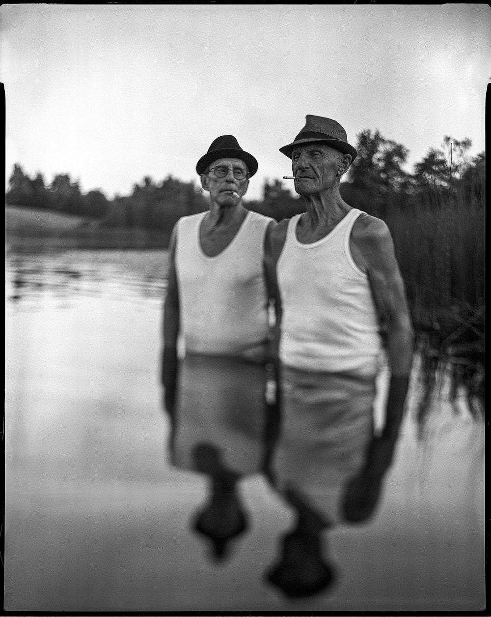 two elder man standing in a lake